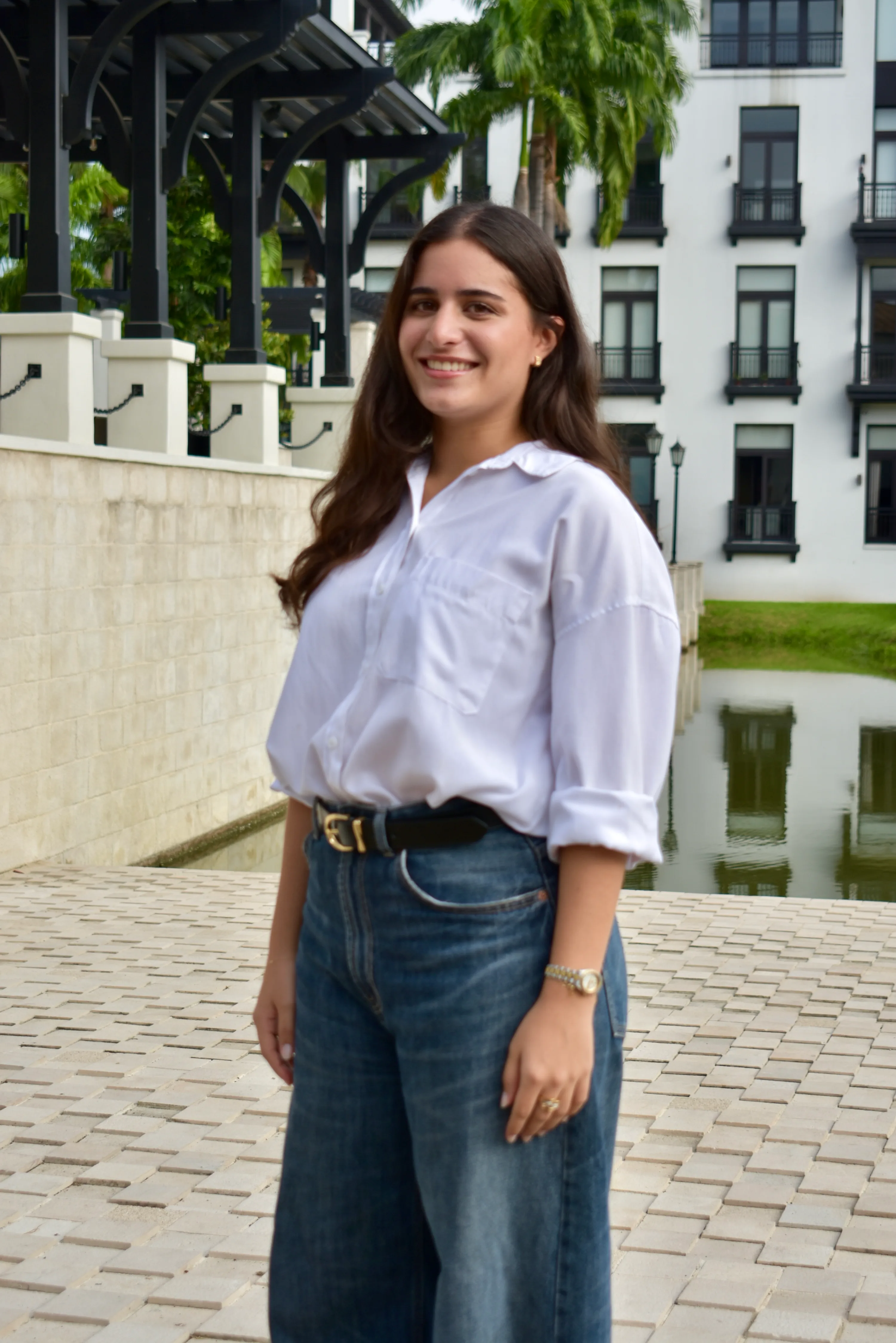 Integrante del equipo MAC con camisa blanca frente a los jardines de Plaza Lagos