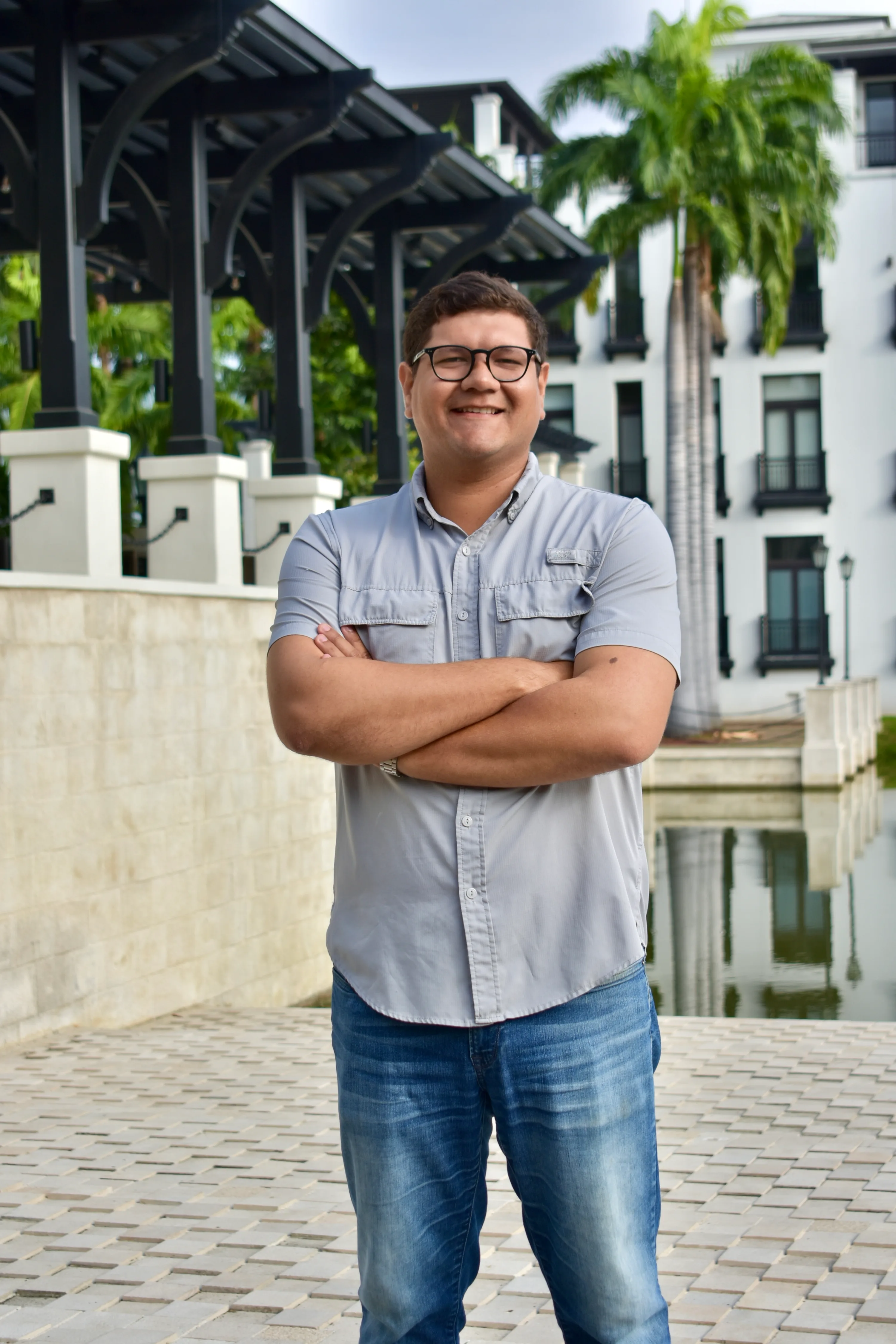 Integrante del equipo MAC con camisa blanca de pie en los jardines de Plaza Lagos