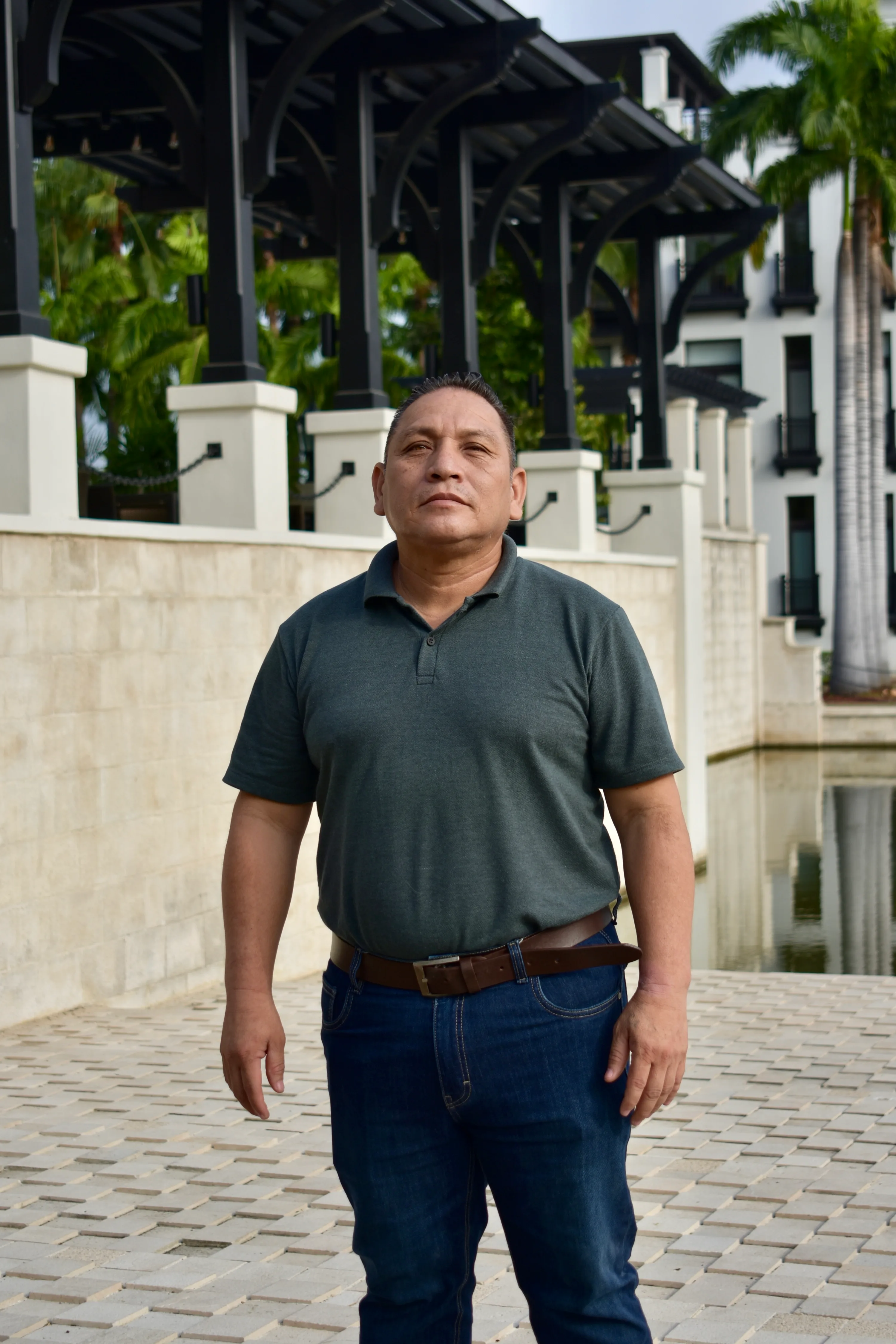 Integrante del equipo MAC con polo oscuro frente a los jardines de Plaza Lagos