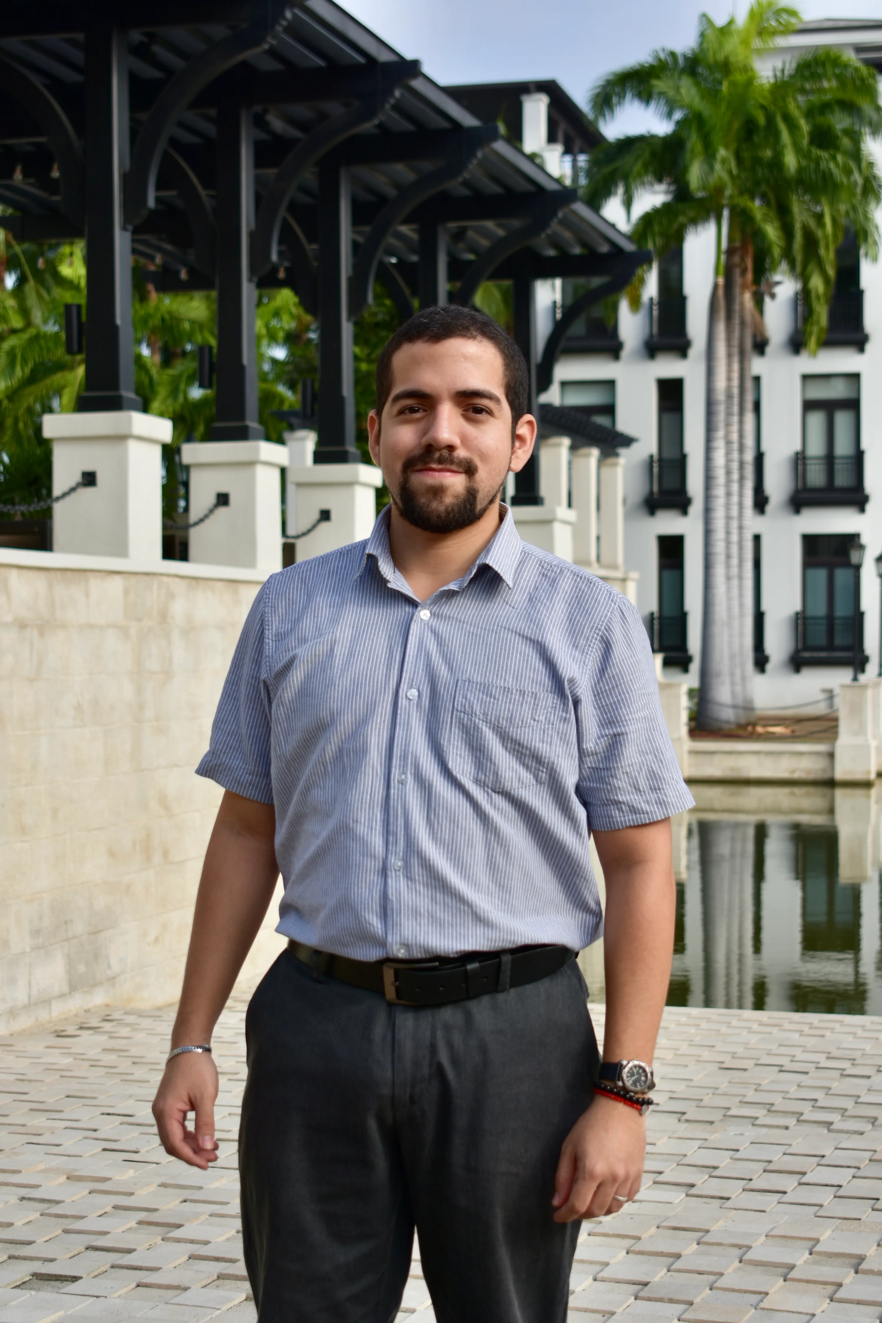 Integrante del equipo MAC con camisa gris frente a la arquitectura de Plaza Lagos