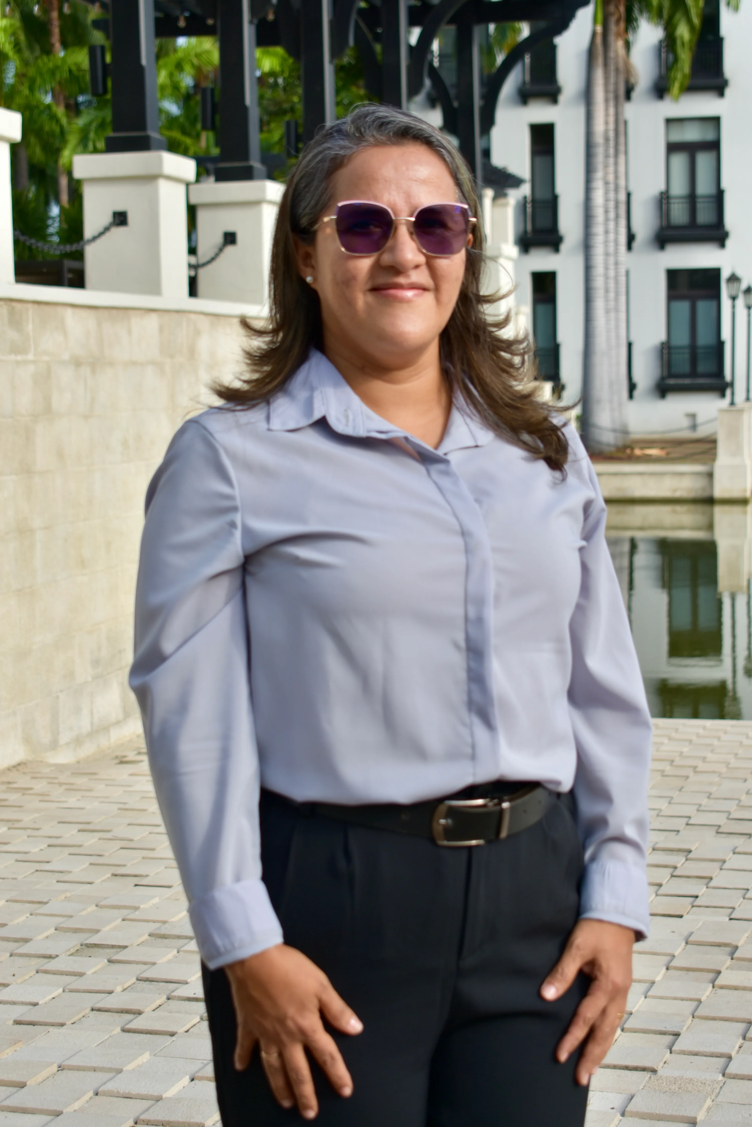 Integrante del equipo MAC con gafas oscuras frente a los jardines de Plaza Lagos