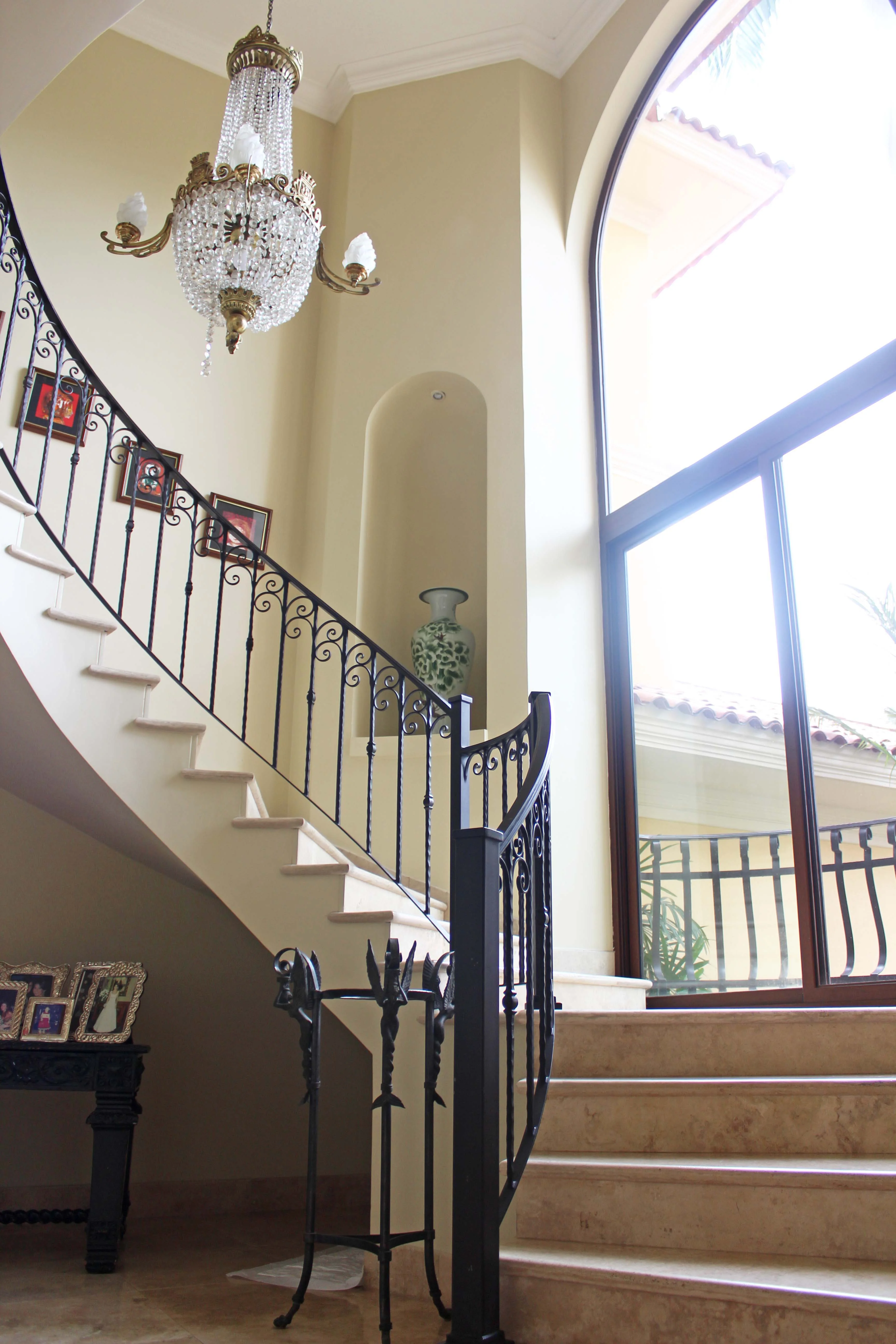 Escalera curva iluminada por un ventanal de doble altura