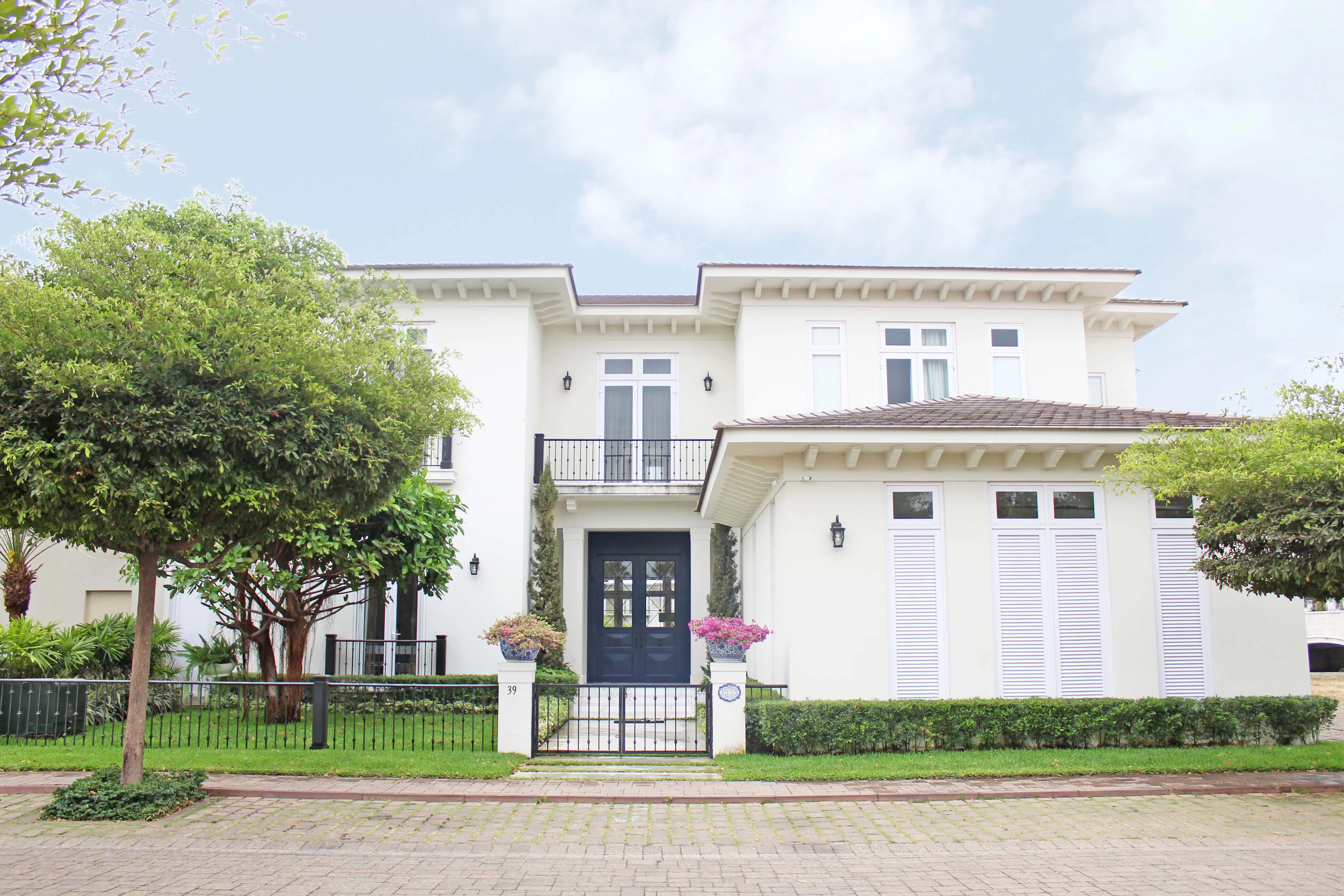 Fachada principal con jardines y pórticos blancos