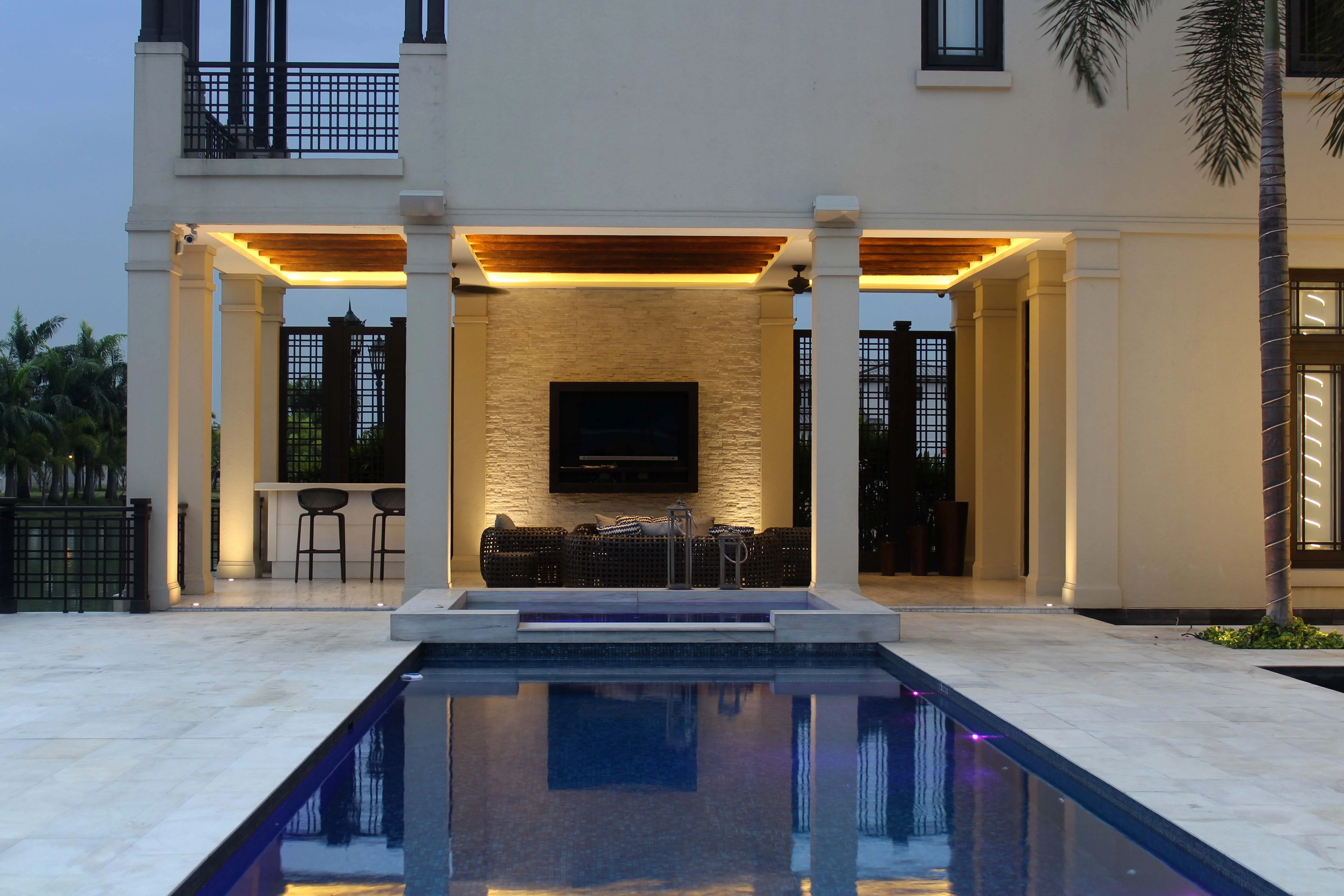 Piscina y terraza iluminadas al anochecer