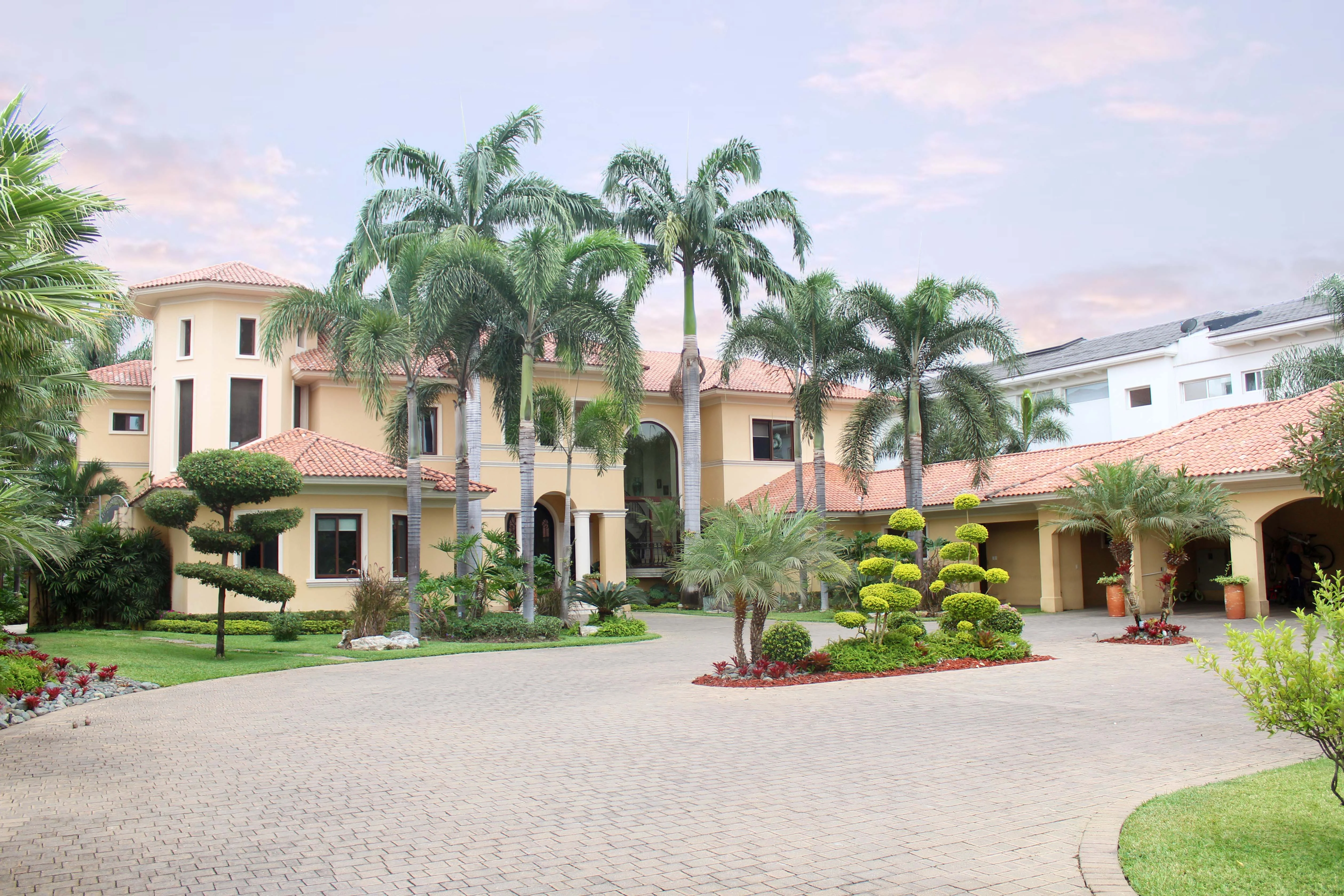 Vivienda rodeada de palmeras y jardines frente a la laguna