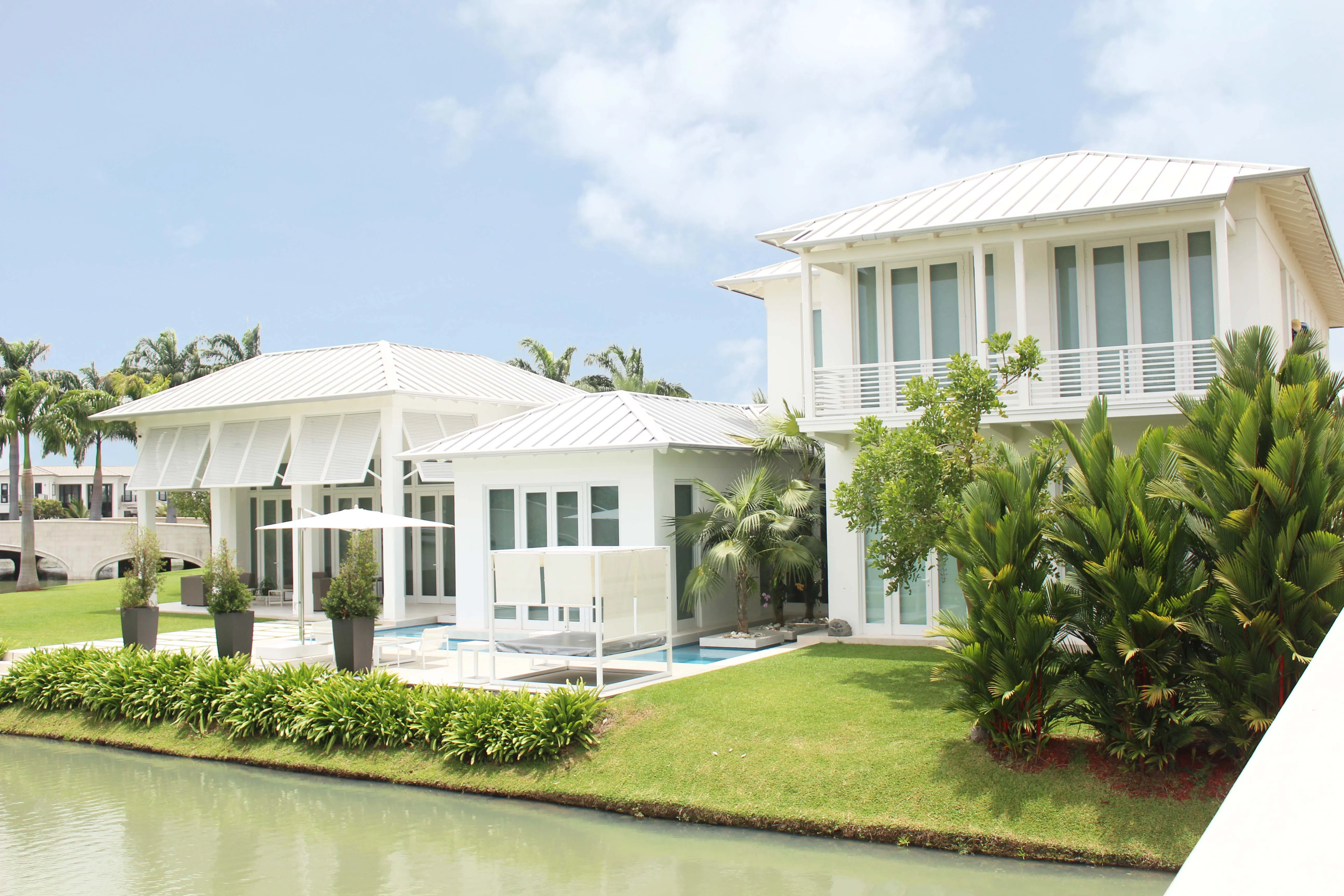 Vivienda blanca con jardín, piscina y borde de laguna