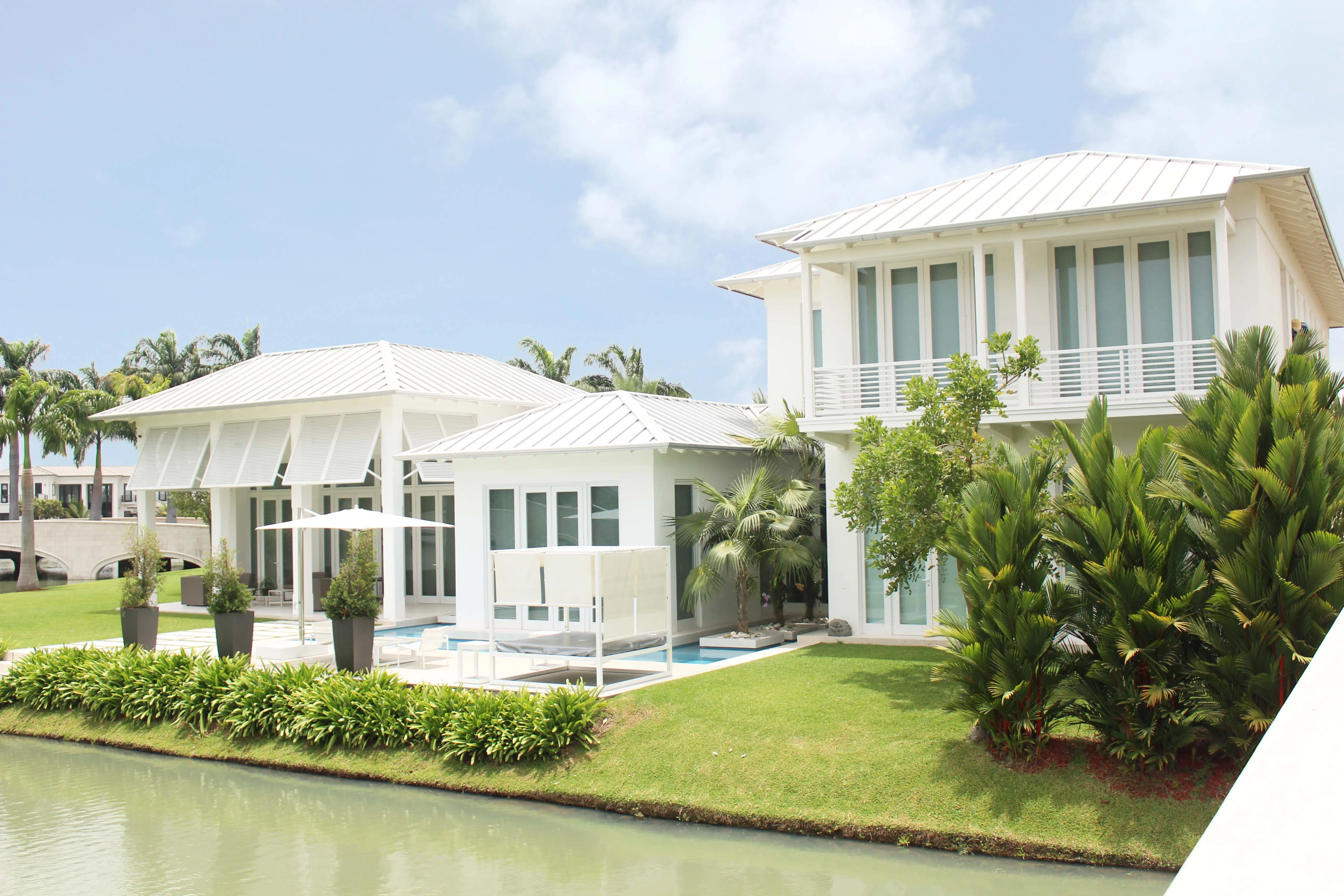 Vivienda blanca con jardín, piscina y borde de laguna